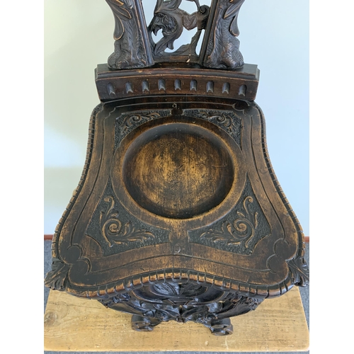 270 - A late 19th/early 20th Century Sgabello style carved wooden hall chair, carved griffon style creatur... 