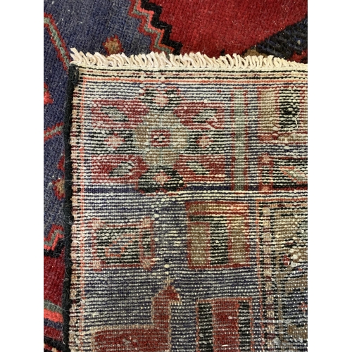 278 - A dark red ground floor rug with small fringe, 77