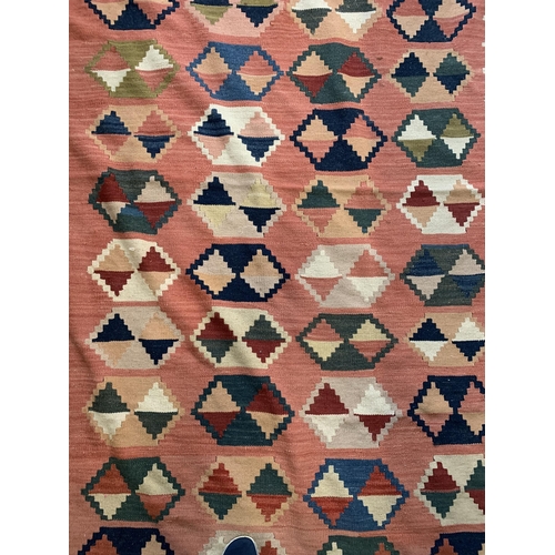 279 - A multi coloured hessian floor rug with tassels, approx. 101