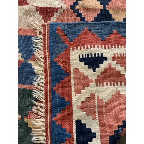 279 - A multi coloured hessian floor rug with tassels, approx. 101