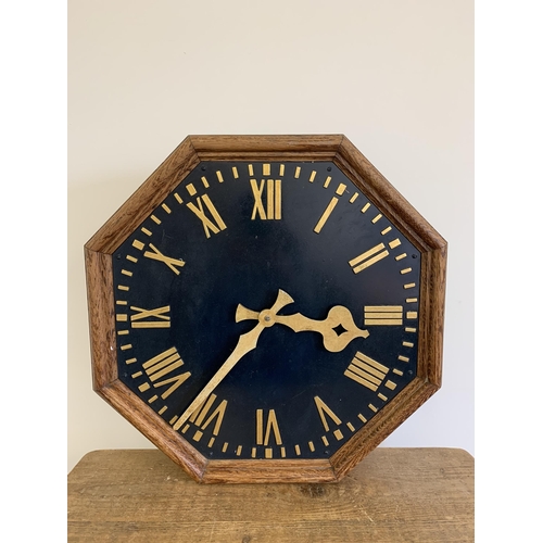 42 - A large oak cased wall clock, formally run by electric, constructed from a heavy brass back plate wh... 