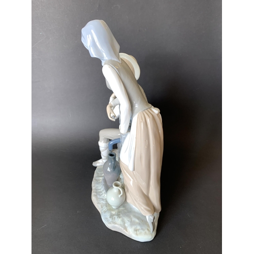 6 - A large Lladro Nao figurine, boy and girl at a well, 13