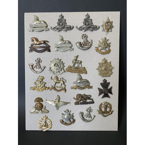 259 - A selection of vintage carded military cap badges