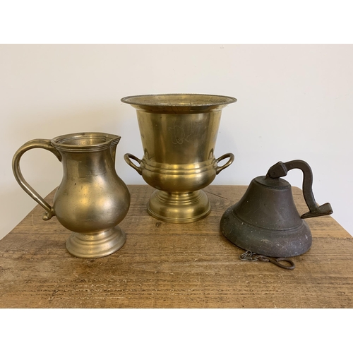 13 - A vintage brass bell with bracket and clapper plus a large brass urn and a solid heavy brass jug