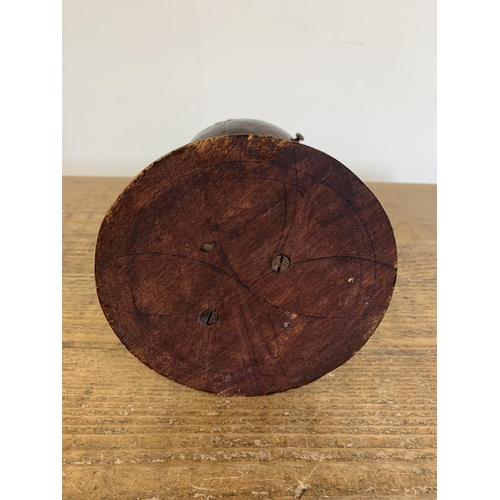 148 - A vintage coconut tobacco holder constructed from a coconut shell hinged in the middle of a wood bas... 