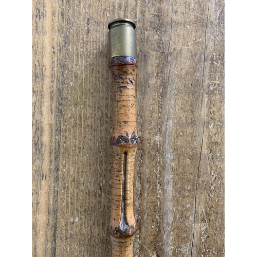 257 - A vintage bamboo type swagger stick with a used Nato shell on the tip, length 30