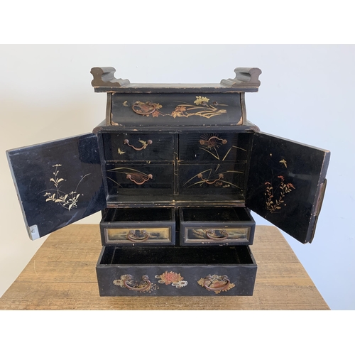 261 - An early 20th Century Oriental black lacquer and hand painted miniature chest/jewellery box with dou... 