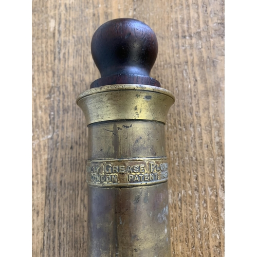 401 - An antique brass and hard wood plunger by Royal Grease