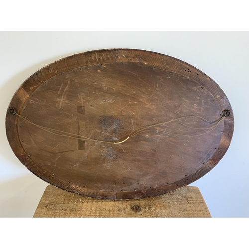 42 - A vintage heavy wood, possibly oak, oval mirror, 34