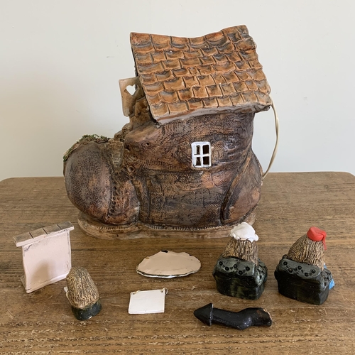 84 - David Taylor Pottery Norfolk, a ceramic boot shaped house wired as a table lamp with hedgehog attend... 