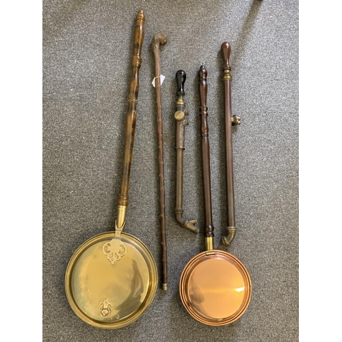 9 - Two vintage warming pans plus two vintage rose sprayers and a walking stick