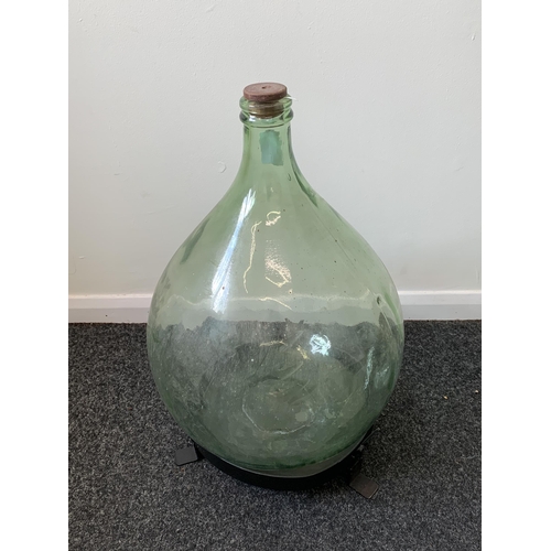 424 - A vintage glass carboy (green glass) with a wood and metal homemade stand, approx. 21