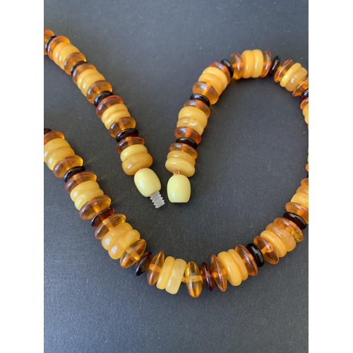 125 - A mixed colour and mixed size discs of amber necklace, approx. 18