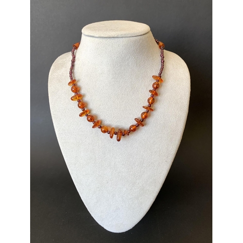 126 - A mixed stone size amber necklace, 15