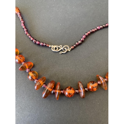 126 - A mixed stone size amber necklace, 15