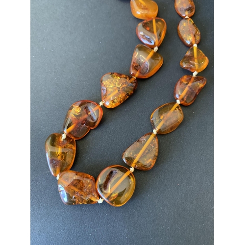 127 - A chunky stone amber necklace, 24