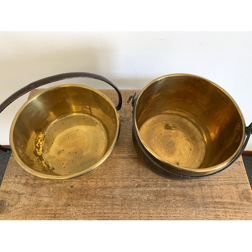 135 - A Victorian brass cauldron plus a brass jam pan, both with iron handles