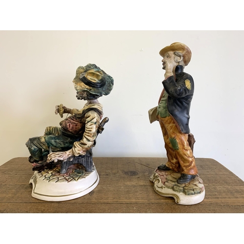 14 - A vintage Capodimonte porcelain tramp figure plus an Italian made porcelain newspaper seller