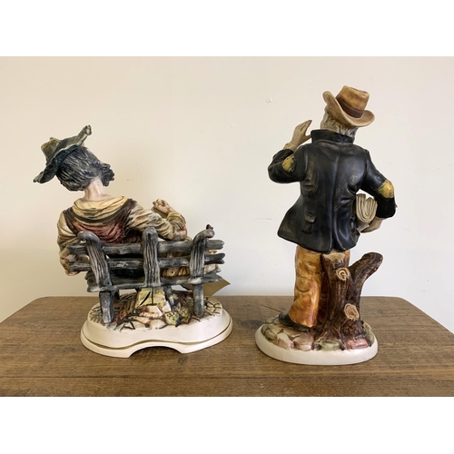 14 - A vintage Capodimonte porcelain tramp figure plus an Italian made porcelain newspaper seller