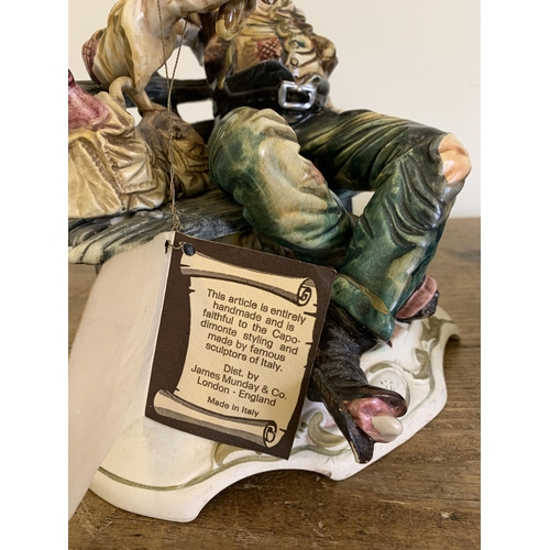 14 - A vintage Capodimonte porcelain tramp figure plus an Italian made porcelain newspaper seller