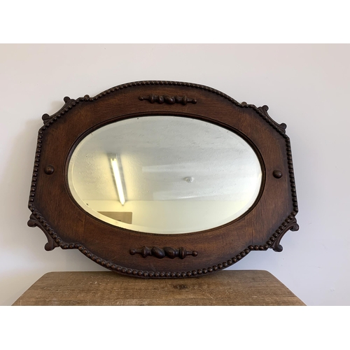 243 - An early 20th Century solid oak wall mirror, approx. 32