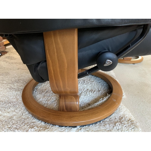 371 - A pair of black leather adjustable armchairs with wood bases and matching foot stool (signs of use)