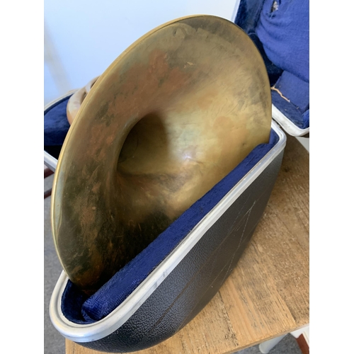 79 - A cased brass French horn (shows signs of much use, metal pitted, requires new mouthpiece, case as f... 