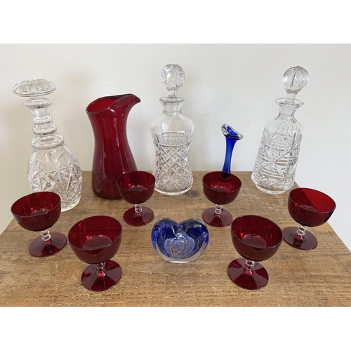 87 - A ruby glass water set, three cut glass decanters plus Art glass