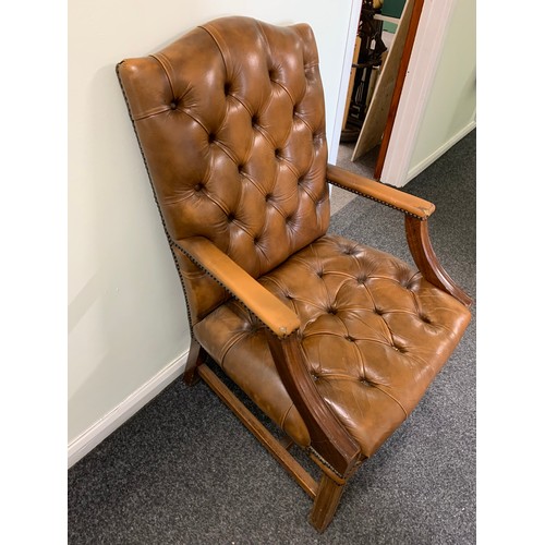 436 - A brown leather Chesterfield style chair (used and wear to arms)