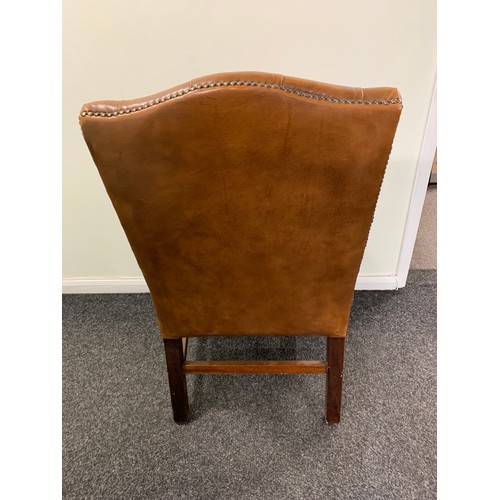 436 - A brown leather Chesterfield style chair (used and wear to arms)