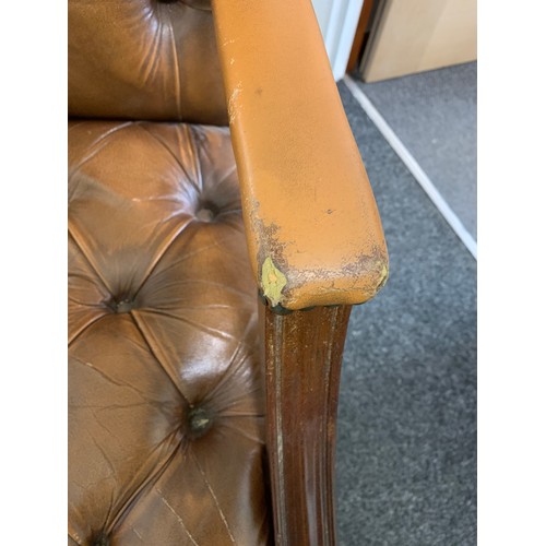 436 - A brown leather Chesterfield style chair (used and wear to arms)