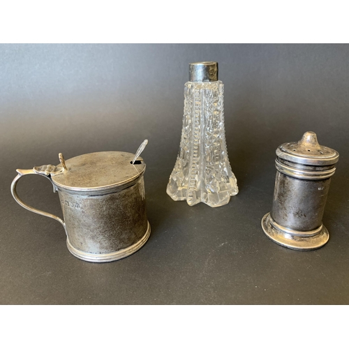 101 - A hallmarked silver mustard pot with blue glass liner and small spoon together with a hallmarked pep... 