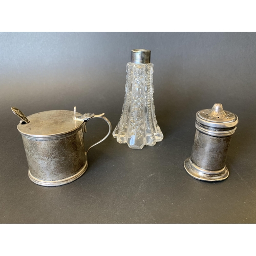 101 - A hallmarked silver mustard pot with blue glass liner and small spoon together with a hallmarked pep... 