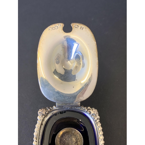 102 - A three piece hallmarked silver condiment set including open salt with blue glass liner, pepper and ... 