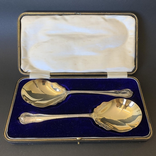 103 - A fine pair of silver plated servings spoons with gilded bowls, in original case