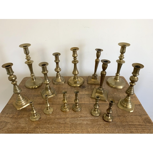 77 - A good selection of antique brass candlesticks, seven pairs and one single