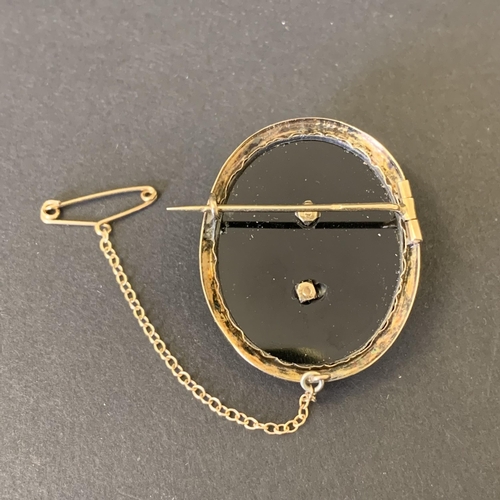 108 - A 585 gold marked diamond set on black onyx brooch with safety chain, total weight approx. 9.5g