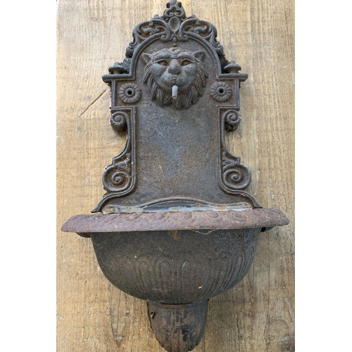 199 - A cast iron lion head garden water feature with sculpted wood back board, 22