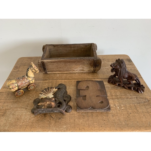 219 - A selection of vintage woodwares including a carved lion, a hand painted toy horse plus a cast iron ... 