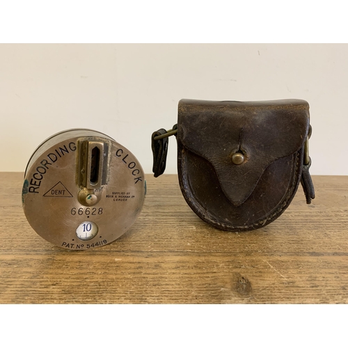 282 - A vintage solid brass watchmans 'Tell Tale' recording clock with leather holder, made by Dent and su... 