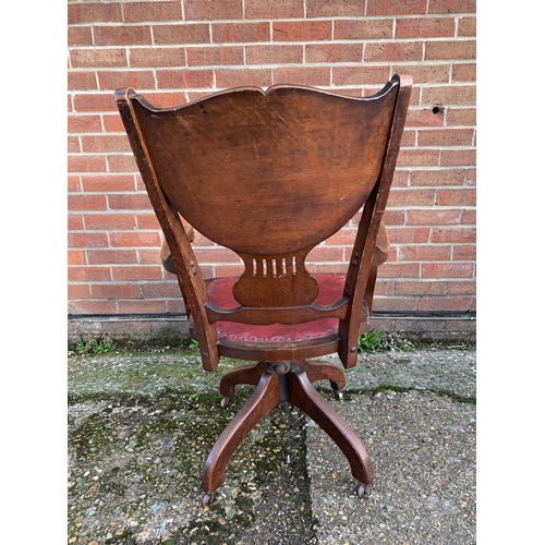 311 - An antique J.S.Ford Johnson and Company Chicago U.S.A. oak revolving office armchair with red leathe... 