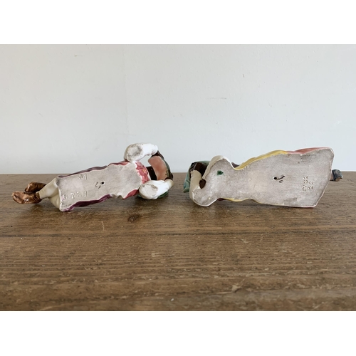 215 - A pair of vintage continental laying down figurines (she with as found foot) plus a Poole dolphin, f... 