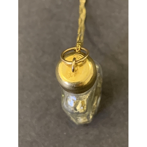 102 - A 9ct gold marked Italy glass bottle with yellow metal filings on a 9ct gold chain