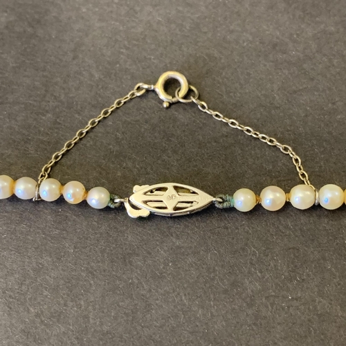 127 - A white metal clasp string of pearls, possibly marked 9c