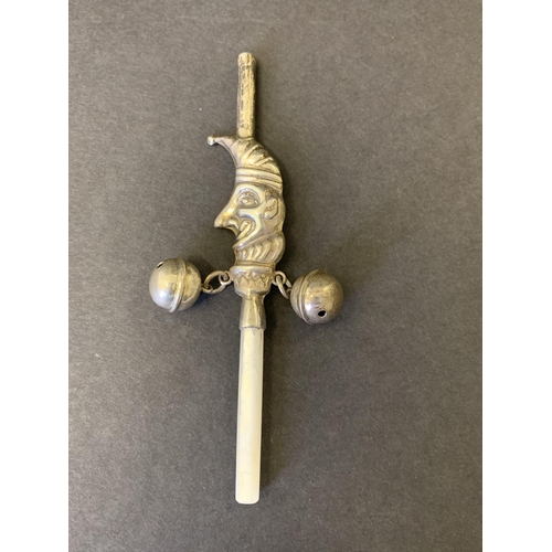 139 - A vintage white metal Mr Punch babies rattle with mother of pearl handle, bells and whistles