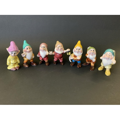 205 - A Disney Store Snow White musical snow dome together with seven Malaysian Disney ceramic dwarfs and ... 