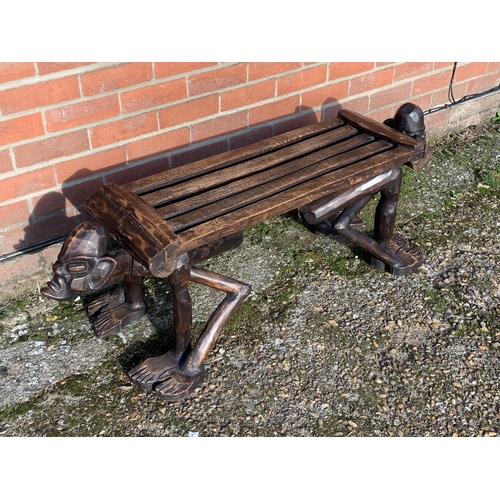 318 - A unusual wooden carved African style bench with heads at each end, 50