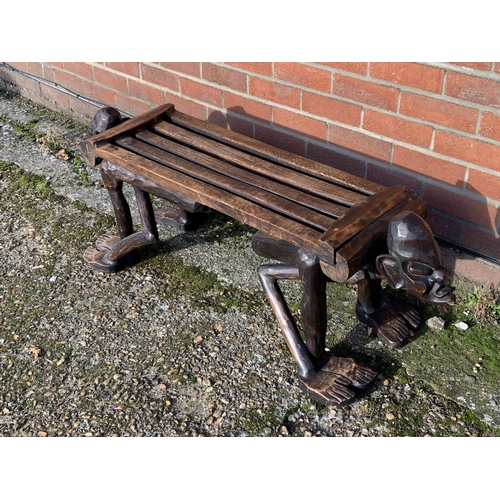 318 - A unusual wooden carved African style bench with heads at each end, 50