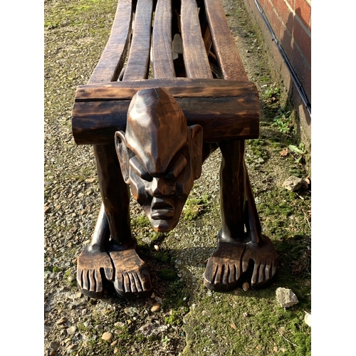 318 - A unusual wooden carved African style bench with heads at each end, 50