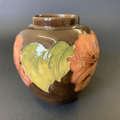 79 - Moorcroft 'Coral Hibiscus' pattern vase on a brown ground, approx. 3